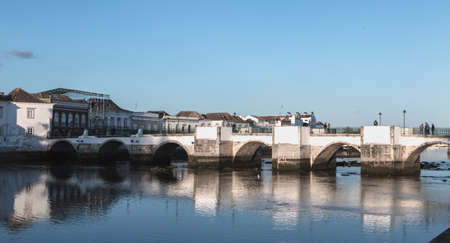 Tavira, Portugal - April 30, 2018: View of the Roman bridge of Tavira that people are crossing on a spring dayのeditorial素材
