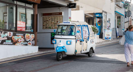 Albufeira, Portugal - May 3, 2018: Tuk Tuk carrying tourists traveling on a street in the historic city center on a spring dayのeditorial素材