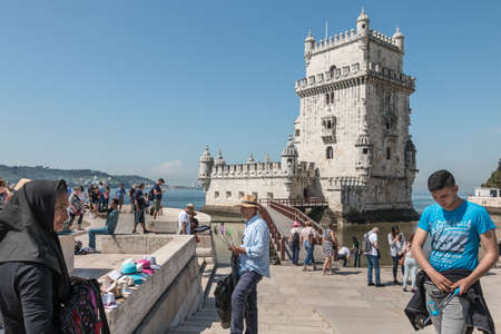 Lisbon, Portugal - May 7, 2018: Sellers of selfie stick and hats attracting tourists in front of Belem tower on a spring dayのeditorial素材