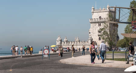 Lisbon, Portugal - May 7, 2018: Tourists walking in front of Belem Tower on a spring day