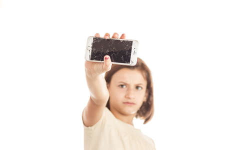 Paris, France - August 26, 2017: sad little girl holding an iphone with broken screen in sudioのeditorial素材