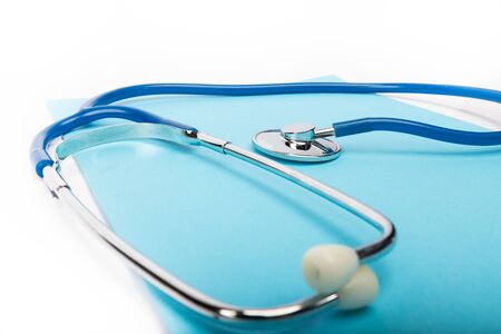 medical record and blue stethoscope close-up on white background in studio