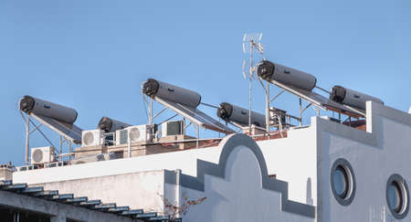 Tavira, Portugal - April 30, 2018: Many air conditioner and solar water heater on the roof of a...