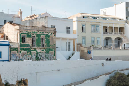 Albufeira, Portugal - May 3, 2018: People looking at a ruined building on the seafront in an upscale...