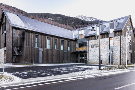 Saint Lary Soulan, France - December 26, 2020: architectural detail of the Maison de Sante (health house) in the historic city center where tourists walk on a winter eveningのeditorial素材