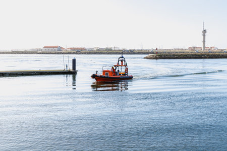 Figueira da Foz, Coimbra, Portugal - October 26, 2020: rescue boat sailing in the city port on an autumn dayのeditorial素材