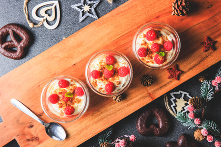 Verrine of crushed speculoos, mascarpone and raspberries on a gray background decorated for Christmas in the studioの写真素材