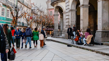 Braga, Portugal - December 24, 2025: Historic city center decorated for the Christmas holidays where people stroll on a winter eveningのeditorial素材