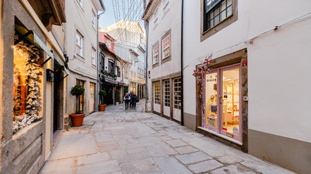 Braga, Portugal - December 24, 2025: Historic city center decorated for the Christmas holidays where people stroll on a winter eveningのeditorial素材