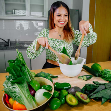 Asian girl cooking healthy vegetarian and vegan food, vegetables and fruits in the kitchen, healthy lifestyleの写真素材