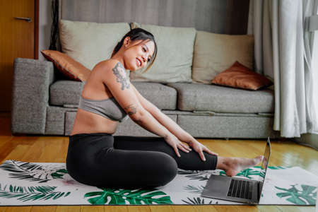 Young Asian healthy woman workout at home, exercise looking at videos, fit, doing yoga, plank, abs,...