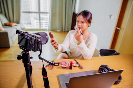 Young beautiful Asian woman professional beauty vlogger or blogger recording make up tutorial to share on social mediaの写真素材