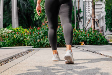 Asian sport girl doing stretching, yoga fitness and plank exercise outside. Fit young thai woman doing training workout in morning.の写真素材