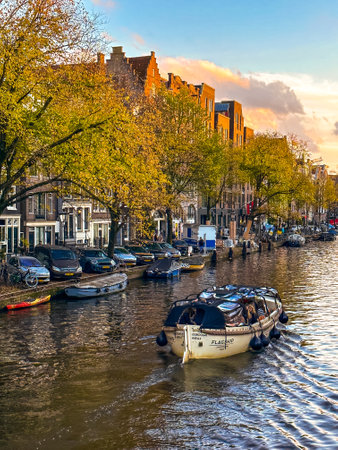 Amsterdam canal view with boats and bicycles at sunset, Netherlandsの写真素材