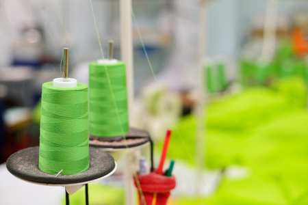 Spools of thread in the sewing equipment. The concept of sewing production.の写真素材
