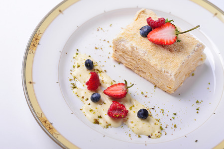Napoleon cake with strawberries, raspberries blueberries, white backgroundの写真素材