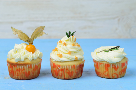 choice of three cupcakes on a blue wooden backgroundの写真素材