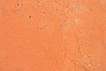 Orange cracked paint on the concrete wall