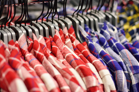 men shirts on rail in clothing store selective focus
