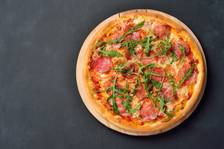 Pizza with salts and arugula on the chalk board with copy space, flat layの写真素材