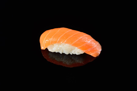 Sushi nigiri with salmon on black background with reflection. Japanese cuisine.の写真素材