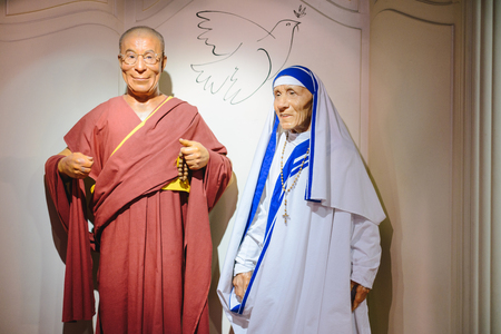 PRAGUE, CZECH REPUBLIC - MAY 2017: The wax figures Dalai Lama and Mother Teresa in the Madame Tussaud Museum in Prague, Czech Republic. Dove of peace between as symbol of love and peace.のeditorial素材