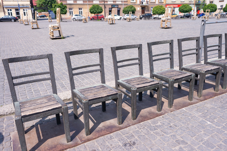 KRAKOW, POLAND - JUNE, 2017: Art objects with iron chairs on cobblestone street erected in memory of Jewish ghetto. Krakow with popul. of 800,000, has 2.35 mill. foreign tourists annuallyのeditorial素材