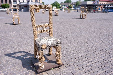 KRAKOW, POLAND - JUNE, 2017: Massive chair on cobblestone street in art installation in memory of Jewish ghetto. Krakow with popul. of 800,000 people has 2.35 mill. foreign tourists annuallyのeditorial素材