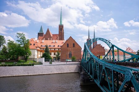 Wroclaw Poland view at Tumski island and Cathedral of St John the Baptist with bridge through river Odra. Picturesque landscape summer day blue sky white cloud.の写真素材