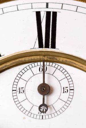 Old clock face detail with roman numerals - focus on the second hand.