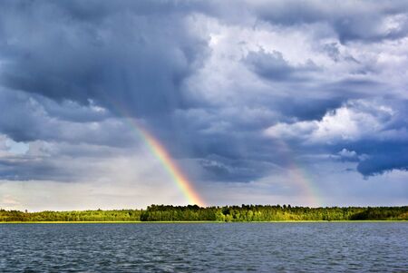 Double rainbow in the moody sky over lake. aRGB.の写真素材