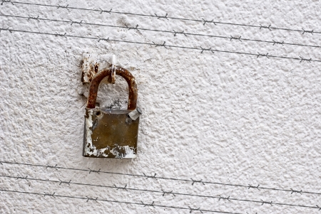 Shadow of barbed wire on wall with padlockの写真素材