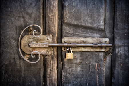 Old latch with padlock on doorsの写真素材