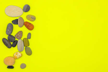 Layout of sea pebbles on a yellow backgroundの写真素材