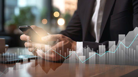 businessman hand with smartphone and bar chart show financial data. business strategy planning and management background conceptの素材