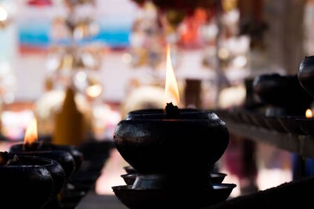 sacred fire, coconut oil lamps in a buddhist temple from Thailandの写真素材
