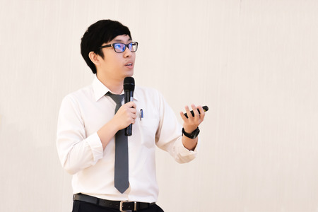 Young male student with black eyeglasses presenting the topic, research in the conferenceの写真素材