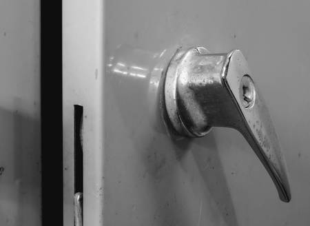 Old and rusty handle with key hole of steel cabinet, black and white effect