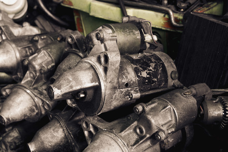 Pile of old and dirty engine  starter motor with selective focus and vintage effect