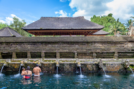 persons pray and bath themselves in the sacred waters of the fountains, in Tirta Empul, Bali, Indonesiaのeditorial素材