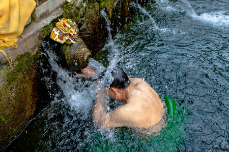 BALI, INDONESIA - DECEMBER 9: Balinese Hindu families come to the sacred springs of Tirta Empul in Bali, Indonesia to pray and cleanse their soul on December 9, 2011.のeditorial素材