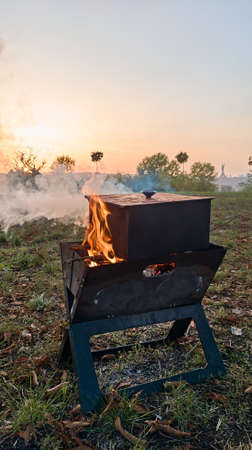 The metal smokehouse is heated by a fire from a brazier. Evening rest at sunset.