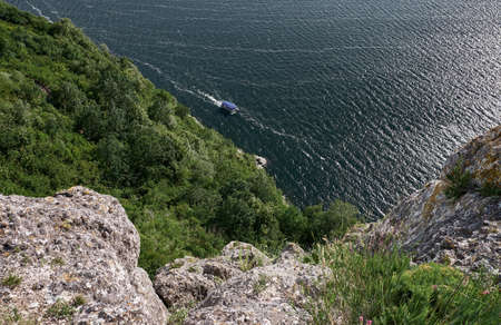 Green coast. Deciduous trees. Rocky shore of the canyon.