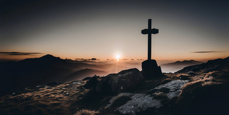 Cross on the top of a mountain in the rays of the rising sunの素材