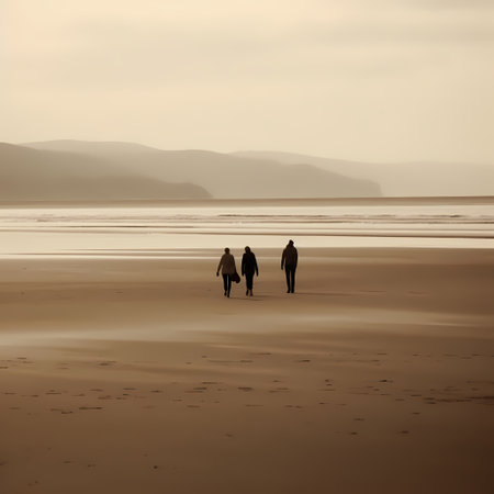 Silhouettes of people walking on the beach at low tide.の素材