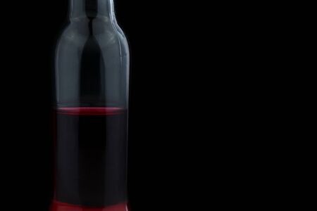 Glass bottle with red water inside on black backgroundの写真素材