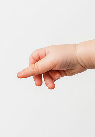 A close-up image of a delicate baby hand reaching out, showcasing soft fingers in a gentle gesture against a plain background, evoking warmth and tenderness.の写真素材