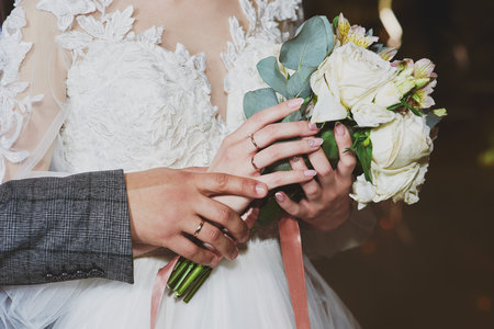 Close up of female hands ties the lacing of wedding dress. Preparation of the bride.の写真素材