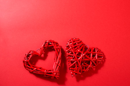 Six white paper sheets pinned with clothespin decorated with wooden hearts. Red background, copy space.の写真素材