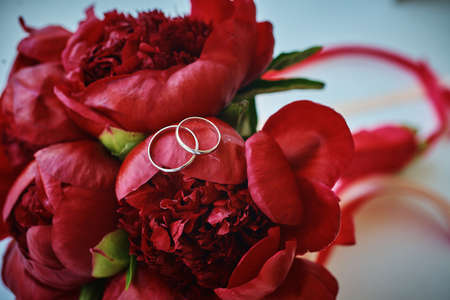 gold rings and a beautiful bridal bouquet of roses on the background. details, wedding traditions. close-up, macroの写真素材